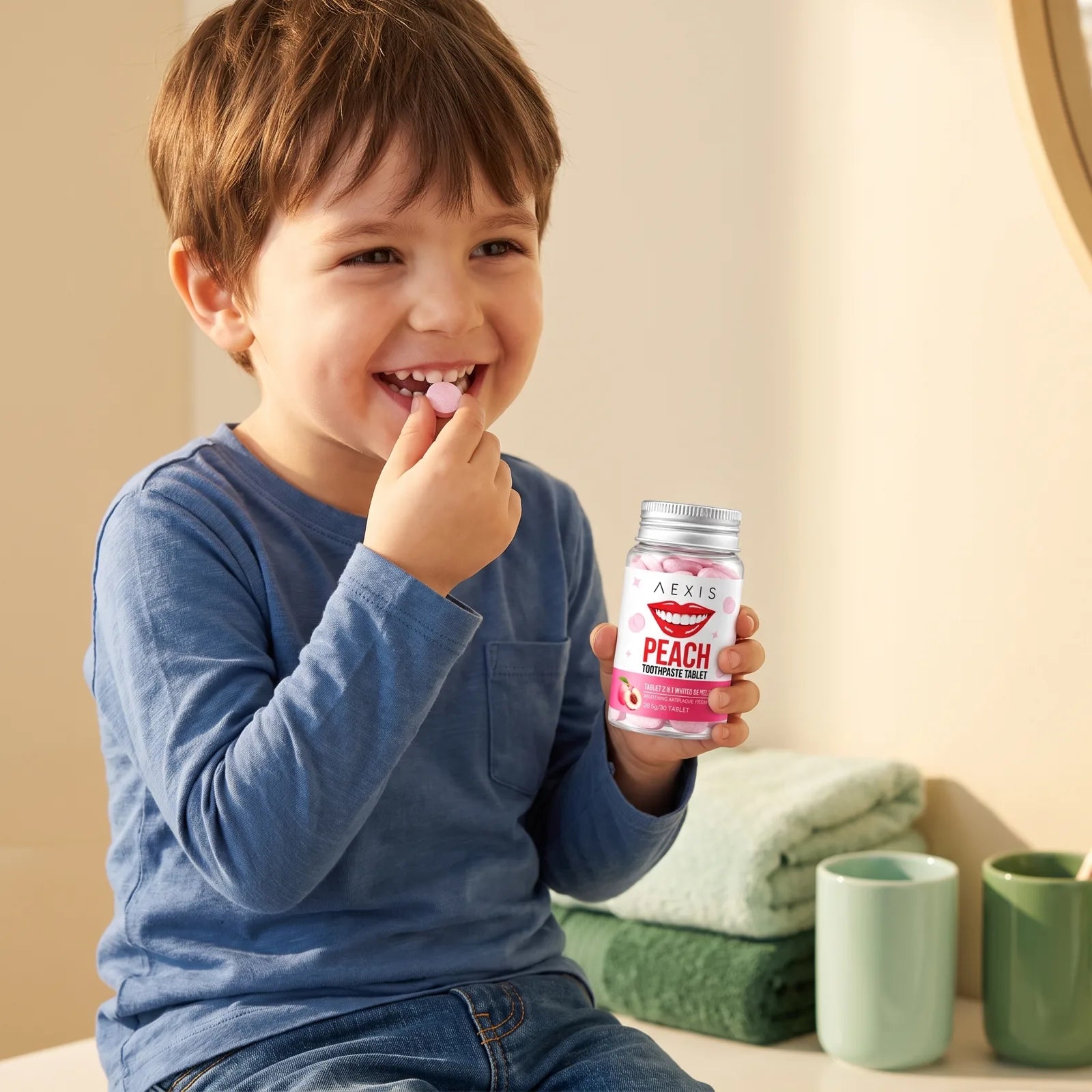 A smiling boy chews a peach tablet